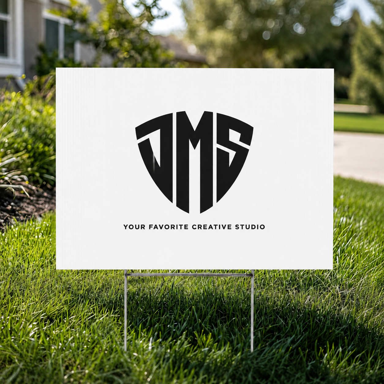Custom printed 18" x 24" coroplast yard sign with DMS Studios logo staked in a front lawn